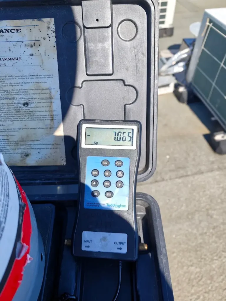 Balance électronique sous une bouteille de fluide frigorigène, lors d’une intervention en toiture