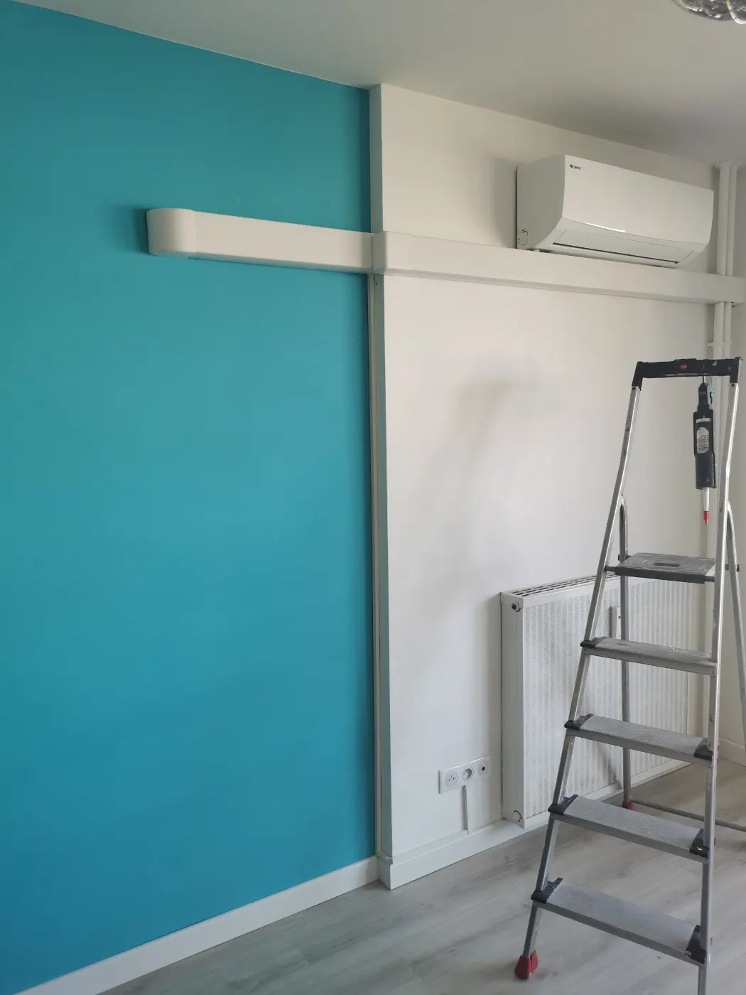 Pièce préparée avant la pose d’une climatisation, escabeau et goulotte en place