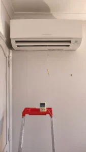 Unité murale de climatisation Mitsubishi Electric et sa télécommande lors de la mise en service