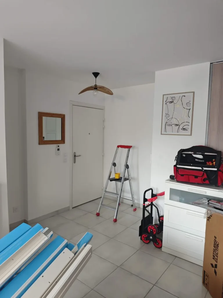 Préparation d’un chantier de climatisation dans un appartement : escabeau, goulottes et outillage
