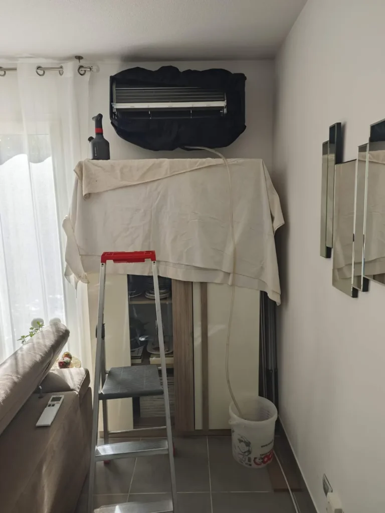 Split mural protégé par une bâche et un drap avant son entretien par Solar&Clim