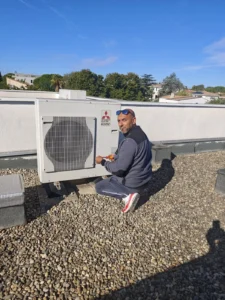 Technicien Solar&Clim branchant une unité extérieure Mitsubishi Electric sur un toit terrasse
