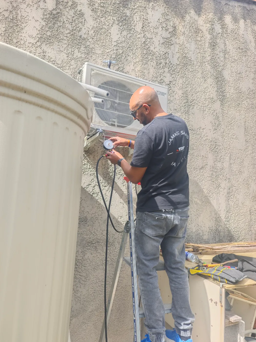 Frigoriste Solar&Clim effectuant des mesures sur une unité extérieure de climatisation