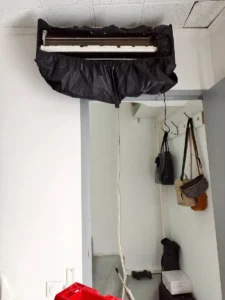 Unité murale de climatisation équipée d’une housse de lavage avant désinfection dans un local professionnel