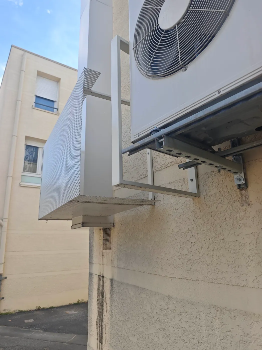 Unité extérieure posée sur console en façade, reliée à une ou plusieurs unités intérieures