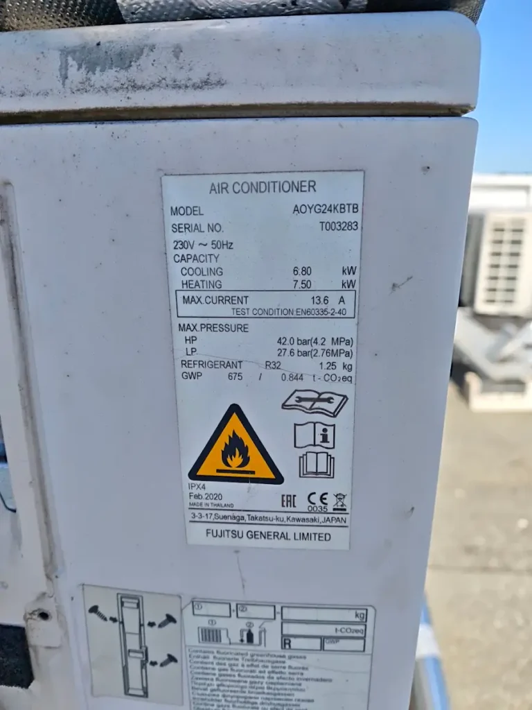 Plaque signalétique d’une unité extérieure Fujitsu indiquant la charge de R32 en kilogrammes et en tonnes équivalent CO2