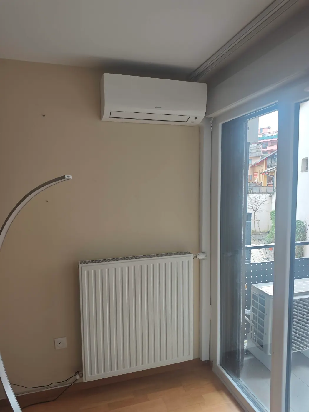Split mural de clim dont la puissance a été choisie pour une chambre équipée d’un radiateur