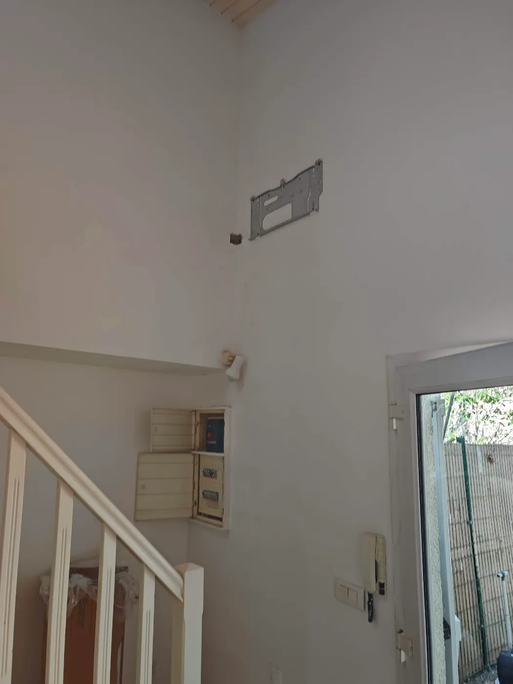 Split mural installé en hauteur dans un hall d’entrée, au-dessus de l’escalier