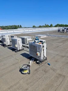 Toiture-terrasse d’un bâtiment professionnel avec plusieurs unités extérieures de climatisation et une station de récupération de fluide