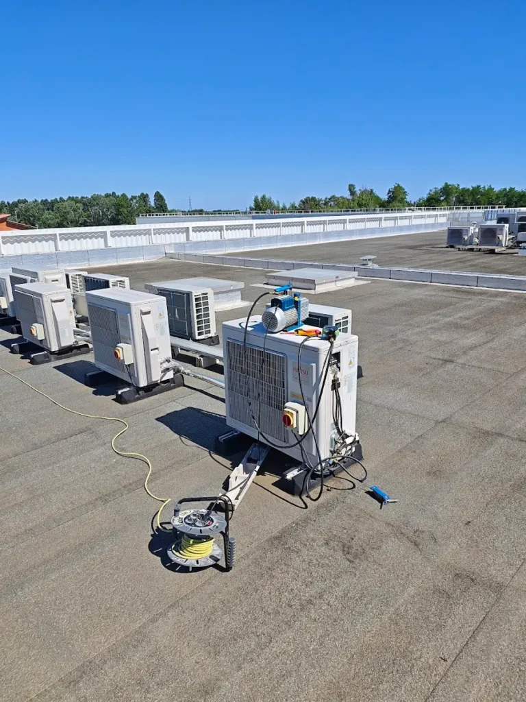 Toiture-terrasse d’un bâtiment professionnel avec plusieurs unités extérieures de climatisation et une station de récupération de fluide