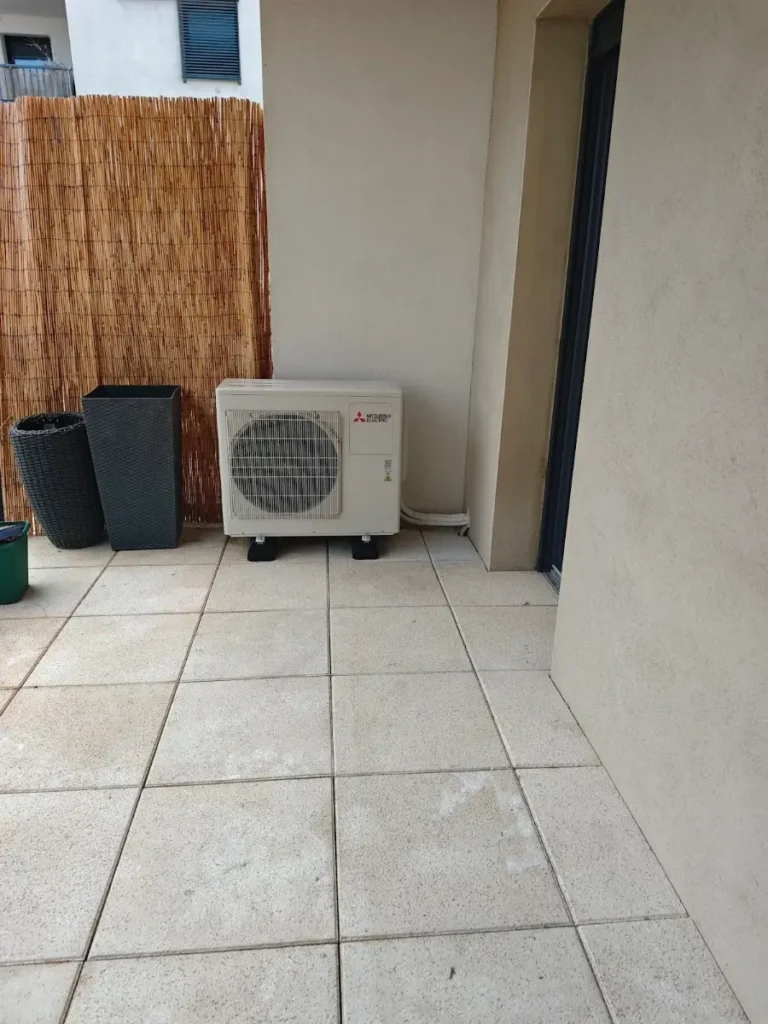 Unité extérieure de pompe à chaleur air-air Mitsubishi Electric posée sur une terrasse carrelée